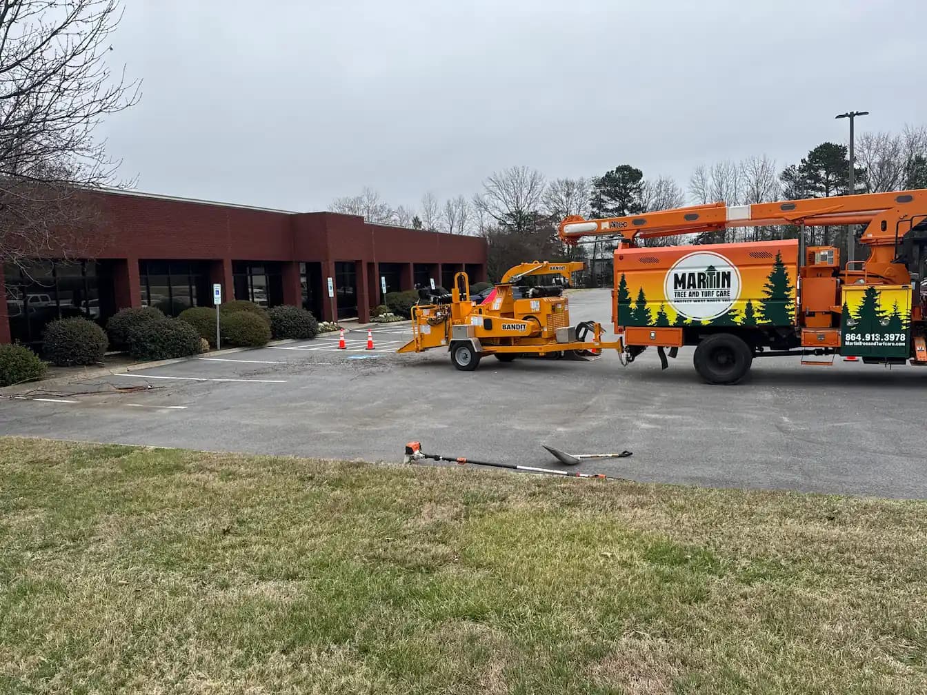 Martin Tree and Turf Care branded bucket truck and chipper at a commercial property in Upstate South Carolina