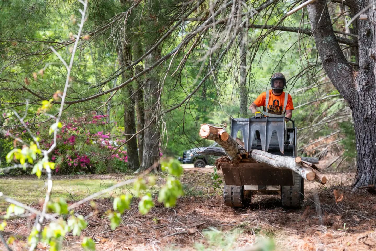 Martin Tree and Turf Care moving a large log with equipment on a commercial tree job in Upstate South Carolina