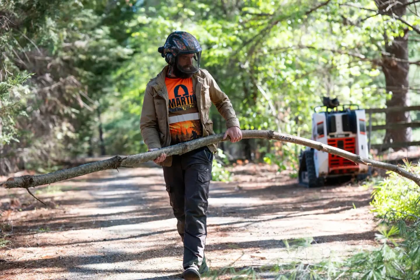 Martin Tree and Turf Care crew moving a limb with a mini track loader in Upstate South Carolina